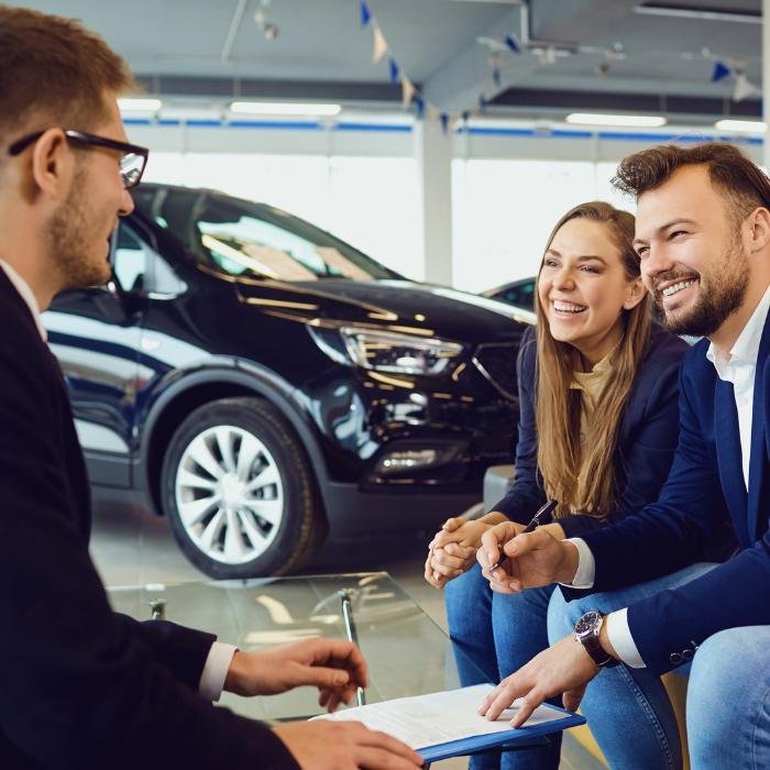 Consulente illustra le loro possibilità a due clienti che intendono acquistare un'auto da Mengarelli Auto SRL – vendita auto a Sirolo